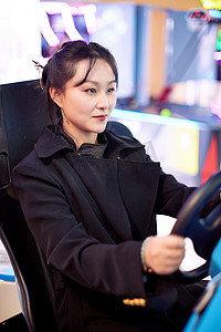 周末在电子游戏娱乐玩赛车游戏的美女