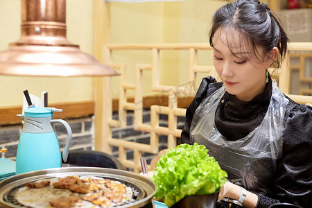 在韩式烤肉店享受美食的亚洲美女
