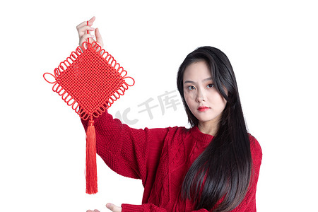 穿红色衣服的年轻女性拿着中国结