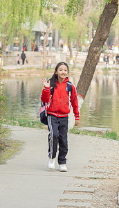 穿着红色校服的小学生户外回头打招呼