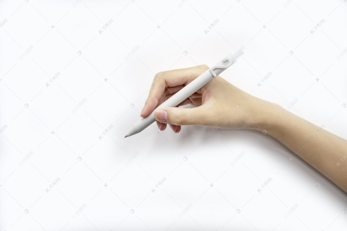 一只手拿着一支铅笔，准备在白色书桌上的粉红色便条纸上写字。照片摄影图片_ID:417928704-Veer图库