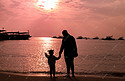 海边日落父亲拉着女儿的手看日落