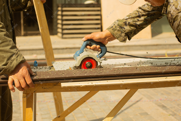 云石机锯木板工人摄影图