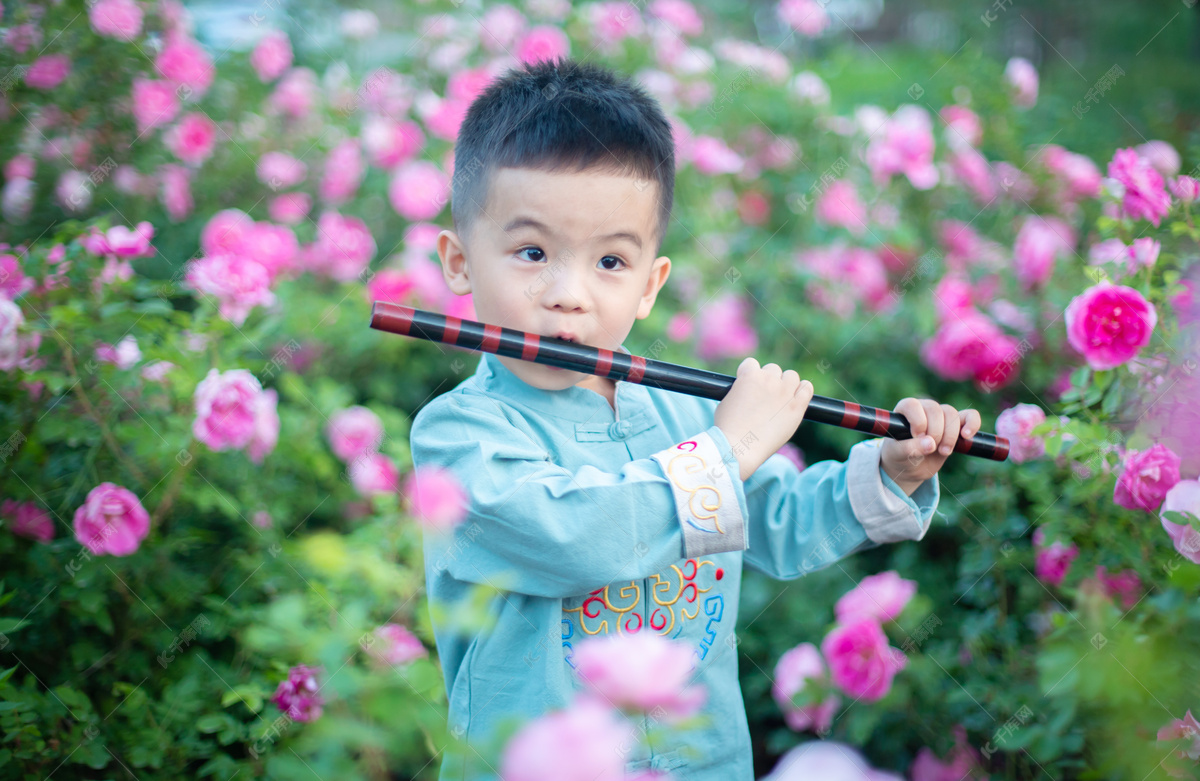 站在花丛里吹笛子的小男孩