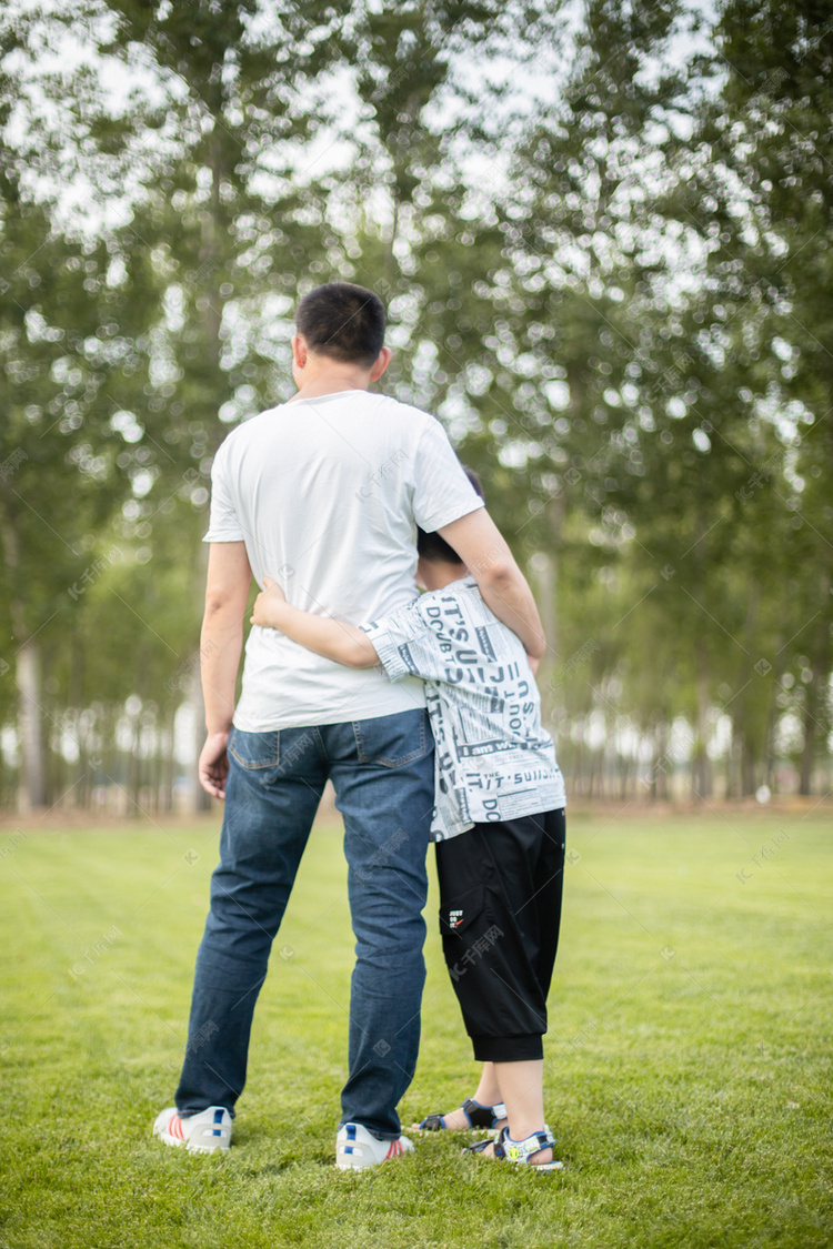 站在草地上的父子俩背影