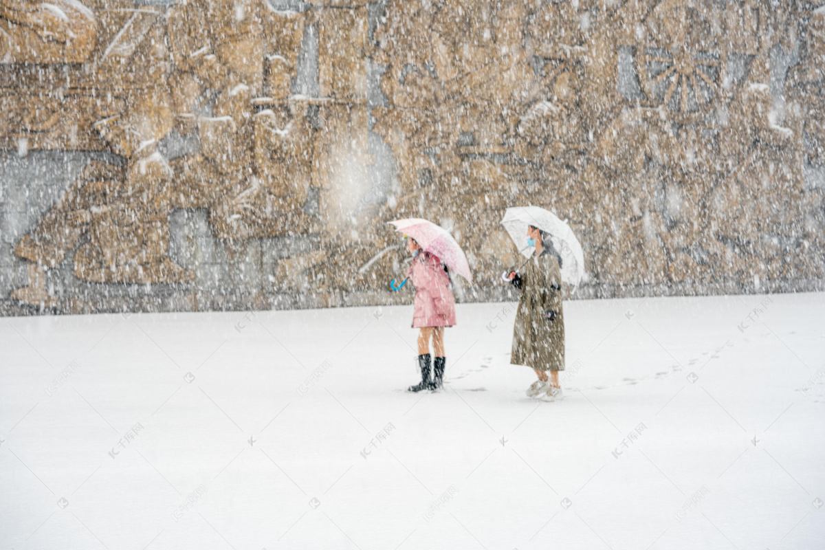 冬天，一个女孩在一棵毛绒绒的松树旁，穿着鲜艳的衣服。这孩子冬天会下雪照片摄影图片_ID:353925096-Veer图库