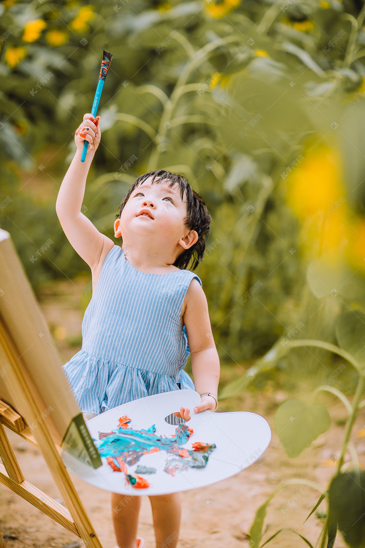 户外儿童白天画画的小女孩公园用画笔指向天空摄影图配图