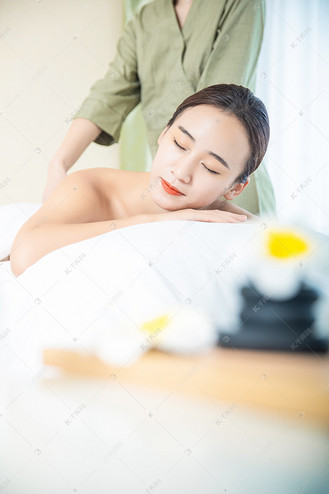 美容养生白天美容养生的美女室内趴在按摩床上摄影图配图