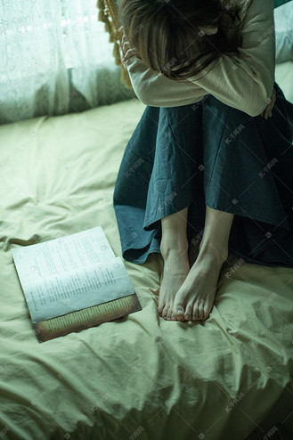 文艺图片傍晚一个美女床上伤心的低头趴着摄影图配图