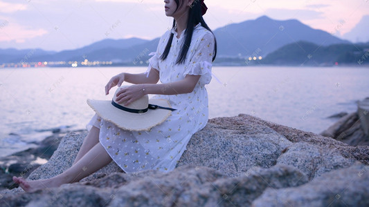 海边礁石上的美女侧面摄影图