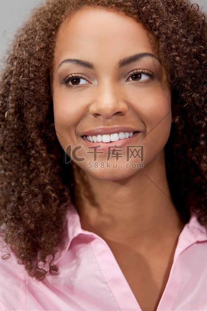 一个美丽的混血非裔美国女孩躺在完美的牙齿和微笑高清摄影大图-千库网