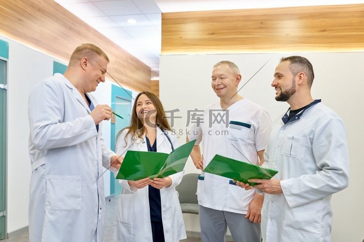 在医院走廊里，一群面带微笑的医生在一起交谈。合照卡通动漫人物高清摄影大图-千库网