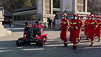 全地形消防机器人和整齐的消防员队伍走过
