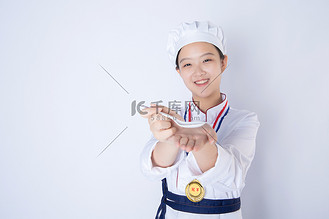 年轻女厨师白天一个女厨师白背景拿小勺冲向镜头摄影图配图