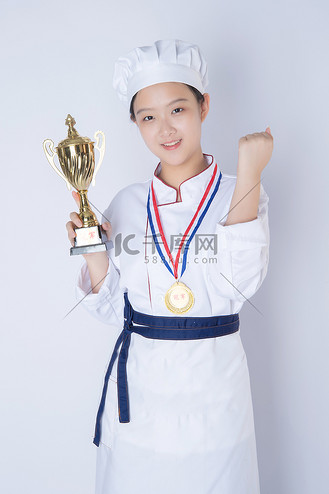 年轻女厨师白天一个女厨师白背景拿着奖杯加油摄影图配图