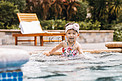儿童夏天白天穿着泳衣的美女户外泳池玩水摄影图配图