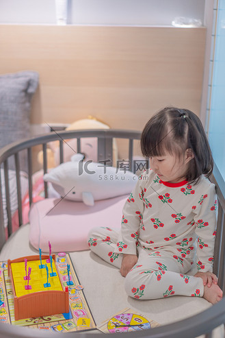 暑假北京图片素材_玩玩具的女孩夜晚女孩卧室半身摄影图配图