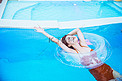 夏日清新白天游泳圈里的美女泳池游泳摄影图配图