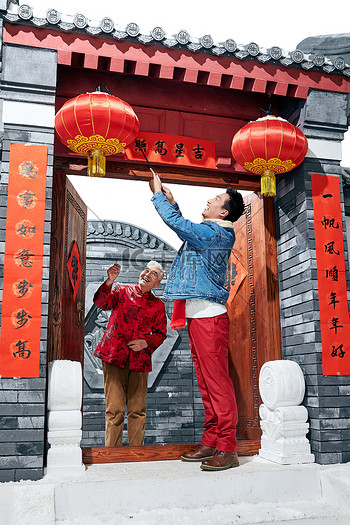 春节大门对联图片素材父子过年挂红灯笼