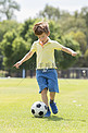 小孩子7或8岁享受快乐踢足球足球在草市公园田野奔跑和踢球兴奋的童年运动激情
