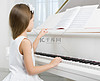 小女孩在弹钢琴的白色连衣裙的侧视图