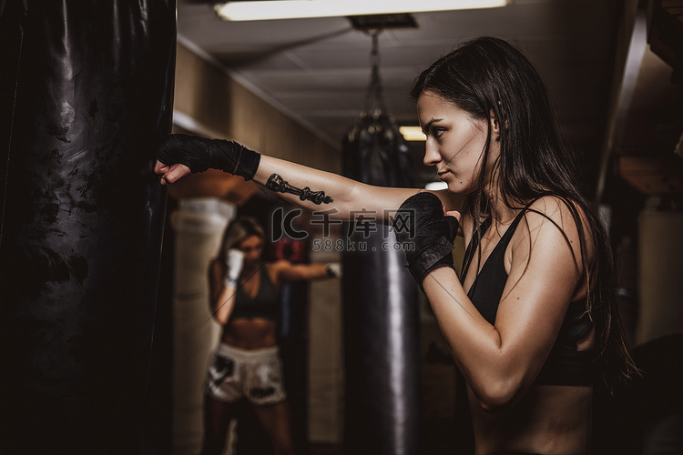 女子拳击手带皮袋训练的肖像高清摄影大图 千库网