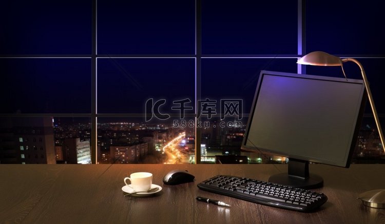 办公室在晚上。晚上在办公室工作，从窗户可以看到城市的景色高清摄影大图-千库网