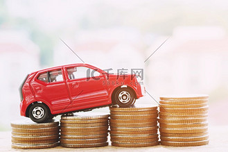  玩具车红色的模型在堆叠的硬币很多钱—保险，贷款和购买汽车金融概念。孤立的白色背景