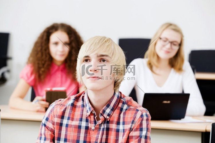 年轻人坐在教室里听讲座。上课的学生高清摄影大图-千库网