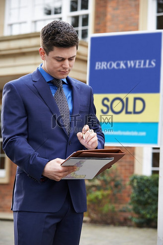 站在住宅物业外的男性房地产经纪人已售出标志西服人物特写