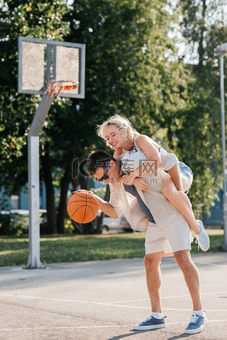 暑假,爱情和人的概念-快乐的年轻夫妇在篮球场上玩球.nba合照