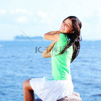 美女泳衣放松在蓝色海洋背景的海滩上