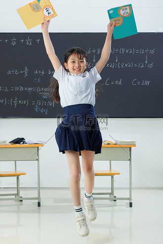 跳跃的女生图片素材_快乐的小学女生在教室里欢呼跳跃