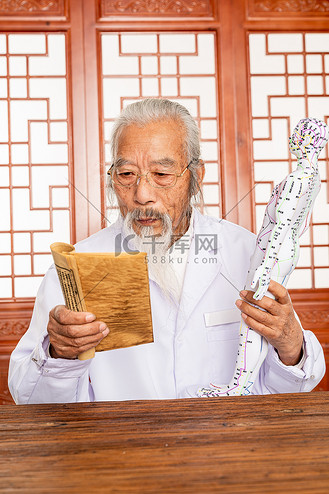 老中医拿着人体针灸穴位模型