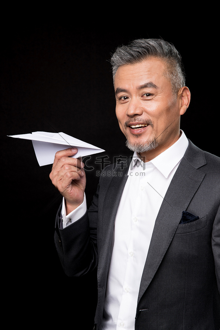 快乐的中老年商务男士拿着纸飞机高清摄影大图-千库网