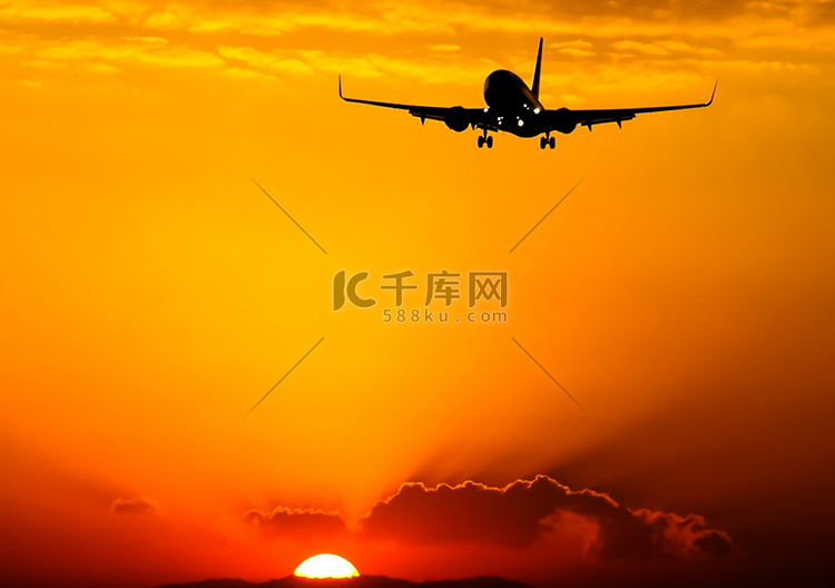 一架客机在夕阳的背景下起飞。高清摄影大图 千库网