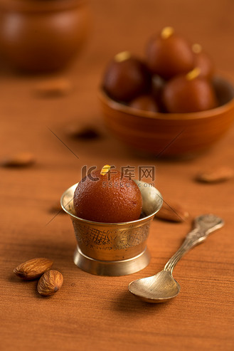碗中的 gulab jamun 和带勺子的古董铜碗.