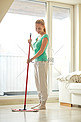在家用拖把清洁地板的快乐女人