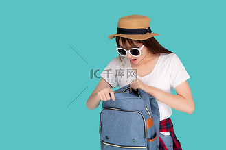 戴着太阳镜和帽子微笑着打开背包旅行暑假假期在假期孤立的蓝色背景