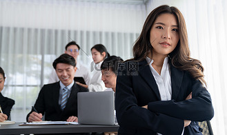 亚洲女经理的焦点肖像与模糊的同事形象和谐相处.