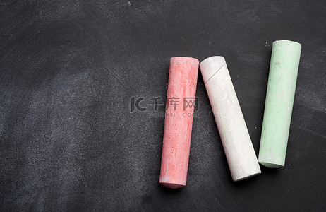 多彩多姿的粉笔躺在空的黑色粉笔板上高清摄影大图-千库网