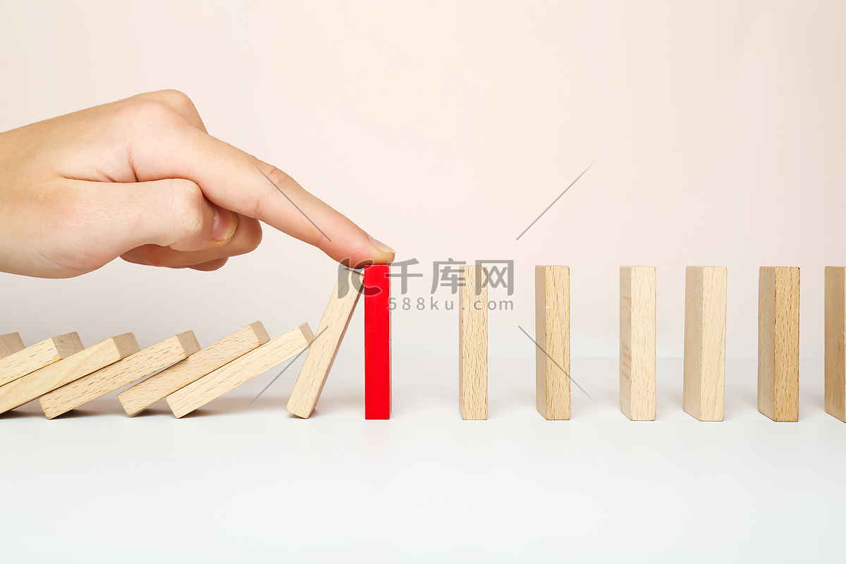 多米诺骨牌倒下，手指停止了连锁反应。高清摄影大图-千库网