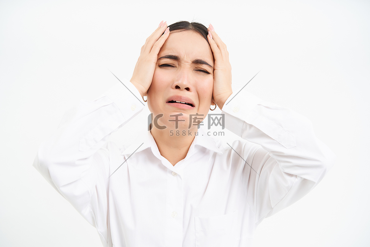 焦虑和忧虑的亚洲女商人的肖像站在白色背景上，手握头，恐慌，看起来紧张和绝望高清摄影大图-千库网