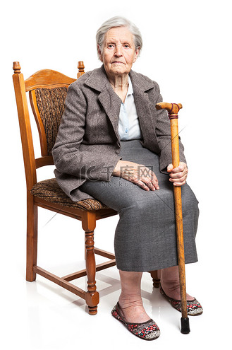 拿着拐杖坐在椅子上的高级女人
