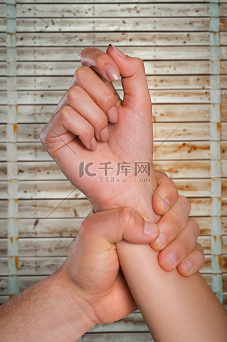 男性手抓女性手腕的复合图像