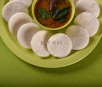 Idli 与 Sambar 在碗中的绿色背景，印度菜：南印度最喜欢的食物 rava idli 或 semolina idly 或 rava ...