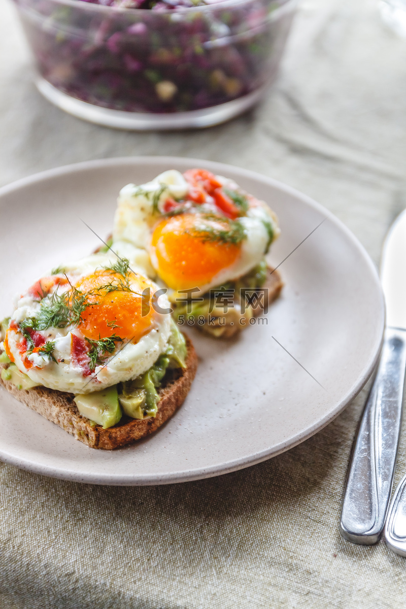 早餐包括两份牛油果吐司、煎鸡蛋和蔬菜高清摄影大图-千库网
