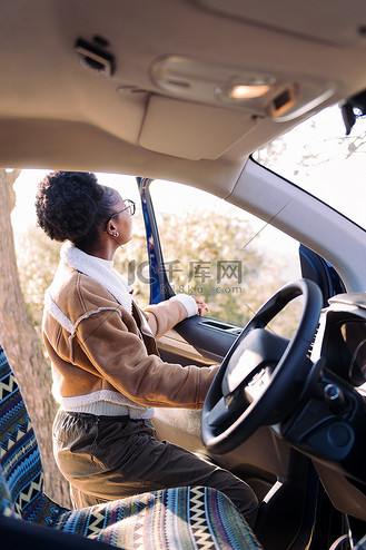 旅途中的年轻女子站在露营车旁