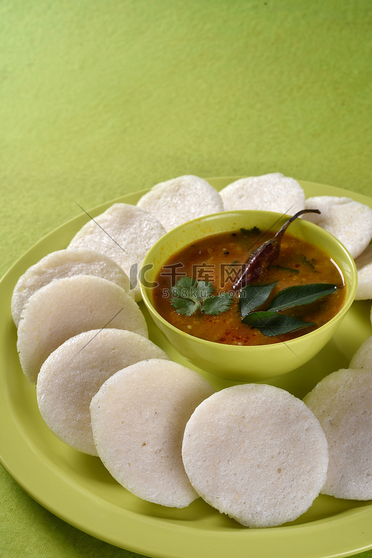 Idli 与 Sambar 在碗中的绿色背景，印度菜：南印度最喜欢的食物 rava idli 或 semolina idly 或 rava ...