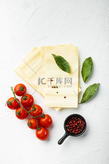 干未煮过的烤宽面条面片配有调味料和香草白色石背景顶视图平躺
